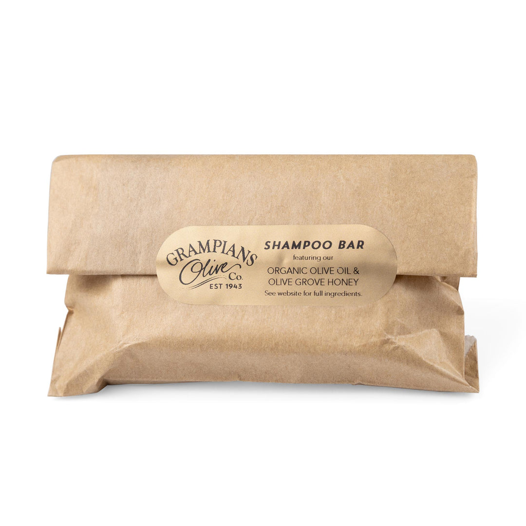 Kraft paper-wrapped shampoo bar with a label on a white background