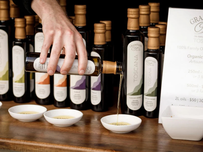 Hand pouring olive oil into a ceramic dish